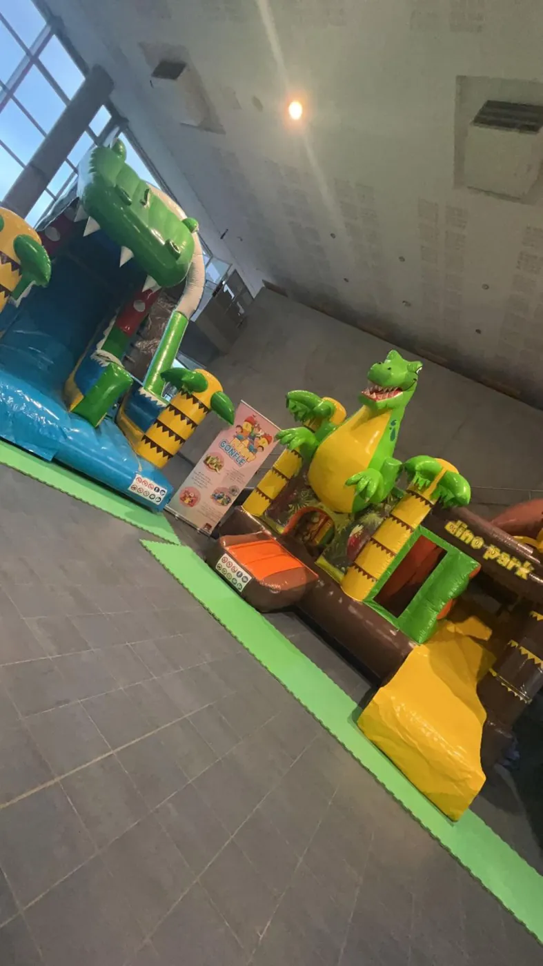 Toboggan gonflable crocodile et structure Dino Park lors d'une animation intérieure
